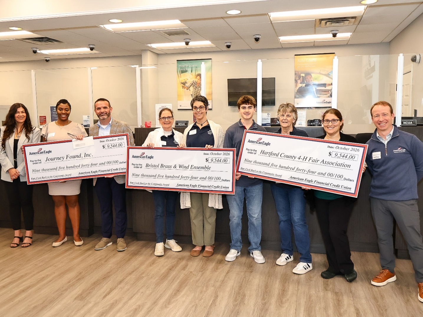 Representatives of American Eagle Financial Credit Union and three Connecticut nonprofit grant recipients holding award checks